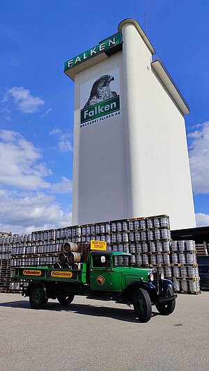 Historischer Siloturm mit vielen Bierfässer davor gelagert und dem Oldtimer-Lastwagen der Brauerei Falken